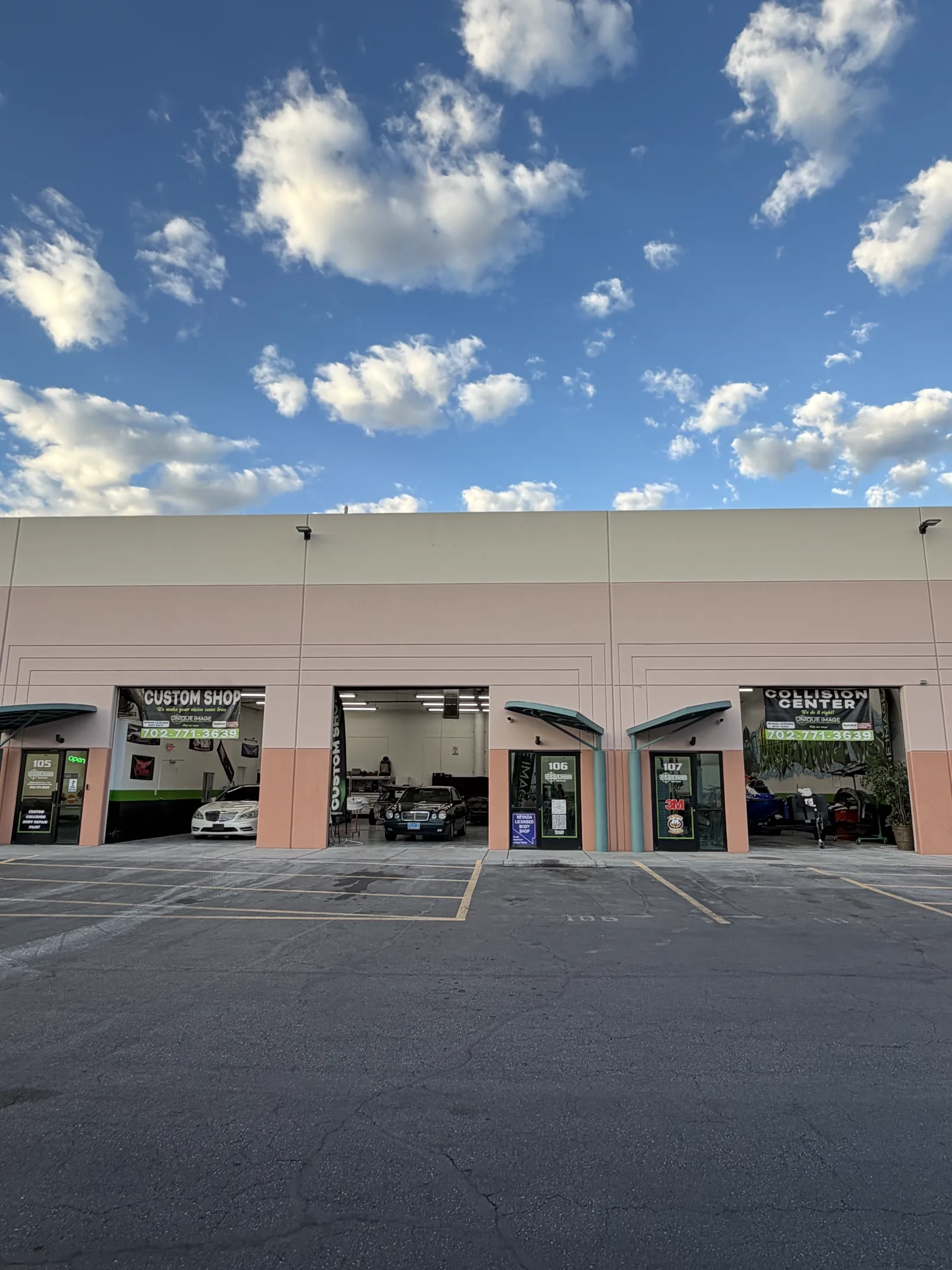 Unique Image Custom Shop and Collision Center banners above the open bays at Suite 105 on North Rancho Drive in Las Vegas